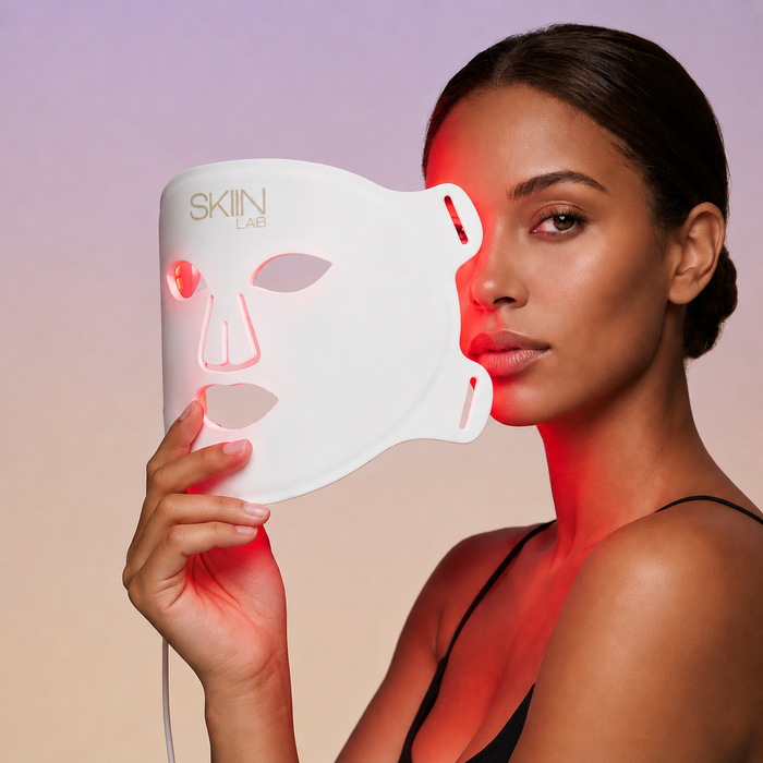 Femme tenant le masque LED visage Lumina 630 avec la lumière rouge allumée sur la peau