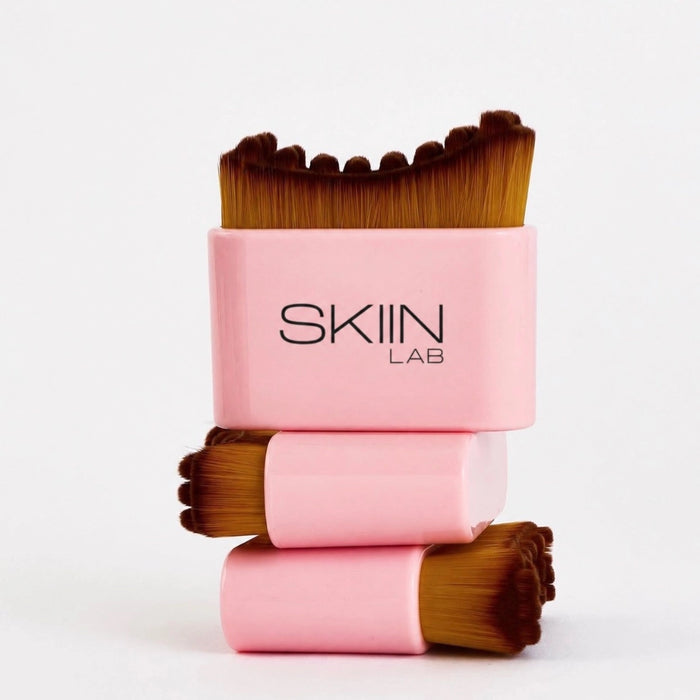Trois brosses visage SkiinLAB empilées, manche rose laqué et poils synthétiques miel en créneaux souples
